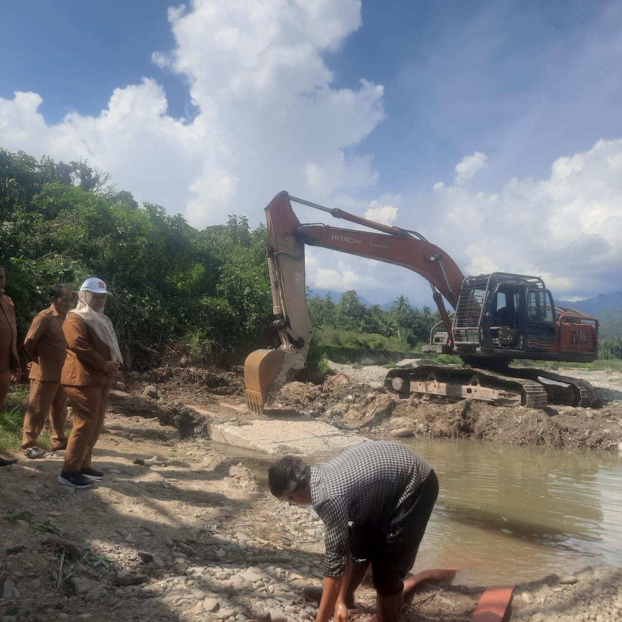 Teks foto Berita Sore/Irham H. Nasution Kadis PUPR Madina Elpi Yanti Harahap mengamati siphon patah jaringan irigasi Sungai Batang Gadis, yang ternyata tersumbat sampah dan material kayu.