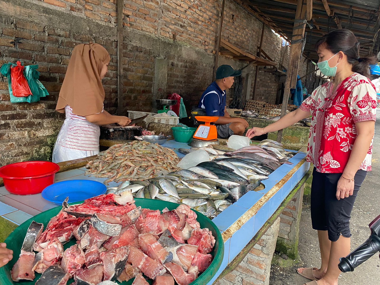 Seorang warga Kisaran sedang belanja di pasar untuk memenuhi kebutuhan keluarga. Pada Periode Maret 2022 angka kemiskinan di Kab Asahan turun menjadi 64,49 ribu jiwa atau 8,64 persen. Foto: Sapriadi