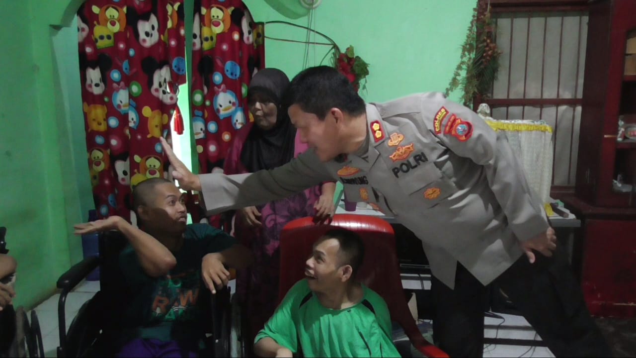 Ket.gbr: Kapolres Simalungun AKBP Ronald FC Sipayung saat berada dan bercengkerama dengan keempat putra Suratmi yang mengalami lumpuh layu sejak lahir.(ist).