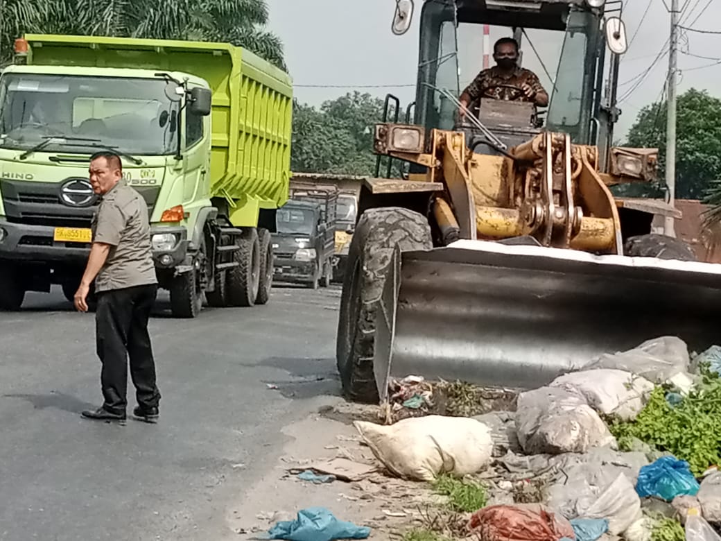 Camat Pulau Rakyat melakukan pembersihan sampah di pinggir Jalinsum. (Berita Sore/Paimin).
