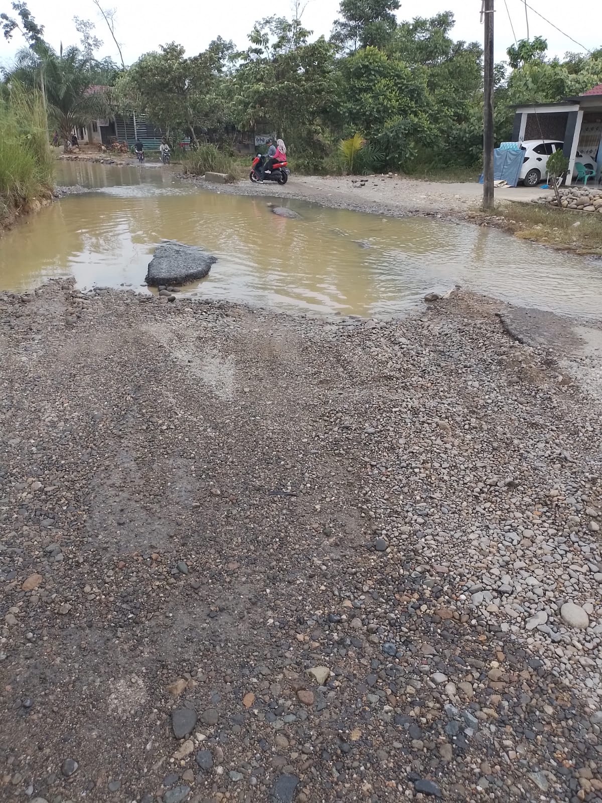 Teks foto: Jalan rusak sering tergenang karena aktivitas pertambangan.