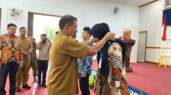 BUPATI Deliserdang H.Ashari Tambunan menyematkan badge atau tanda pengenal kepada salah seorang petugas yang akan melakukan verifikasi pendataan warga miskin di Balairung Pemkab Deliserdang, Selasa (26/9).- (Foto: Khairul K Siregar)