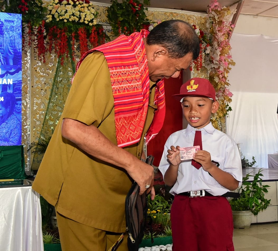 Teks foto : BUPATI Deliserdang H.Ashari Tambunan berdialog dengan salah seorang siswa SD usai menyerahkan Kartu Identitas Anak (KIA) pada kunjungan kerja di Kecamatan Pancur Batu, Selasa (3/10).- (Khairul K Siregar)