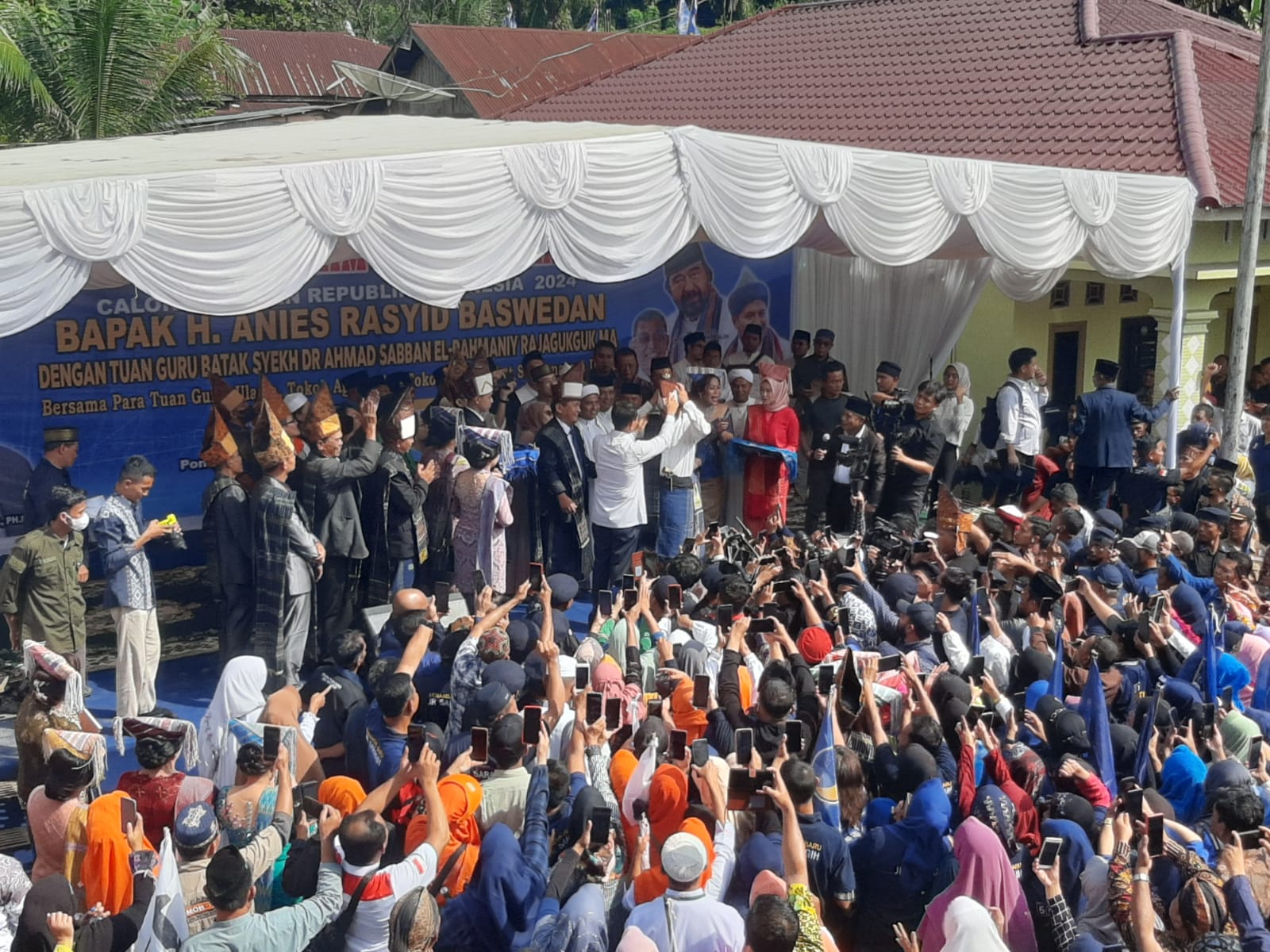 Bacapres Anies Baswedan di dampingi istri saat diberi seperangkat kain Simalungun oleh Ihutan Bolon Saragih Garingging, Jumat (03/11/2023) pagi.(Foto: Hasuna Damanik).