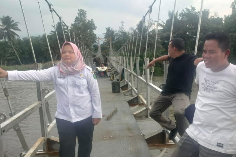 Teks foto: Kadis PUPR Madina Elpi Yanti Sari Harahap, ST di jembatan gantung Desa Kampungbaru, Panyabungan Utara, Madina. beritasore/Ist