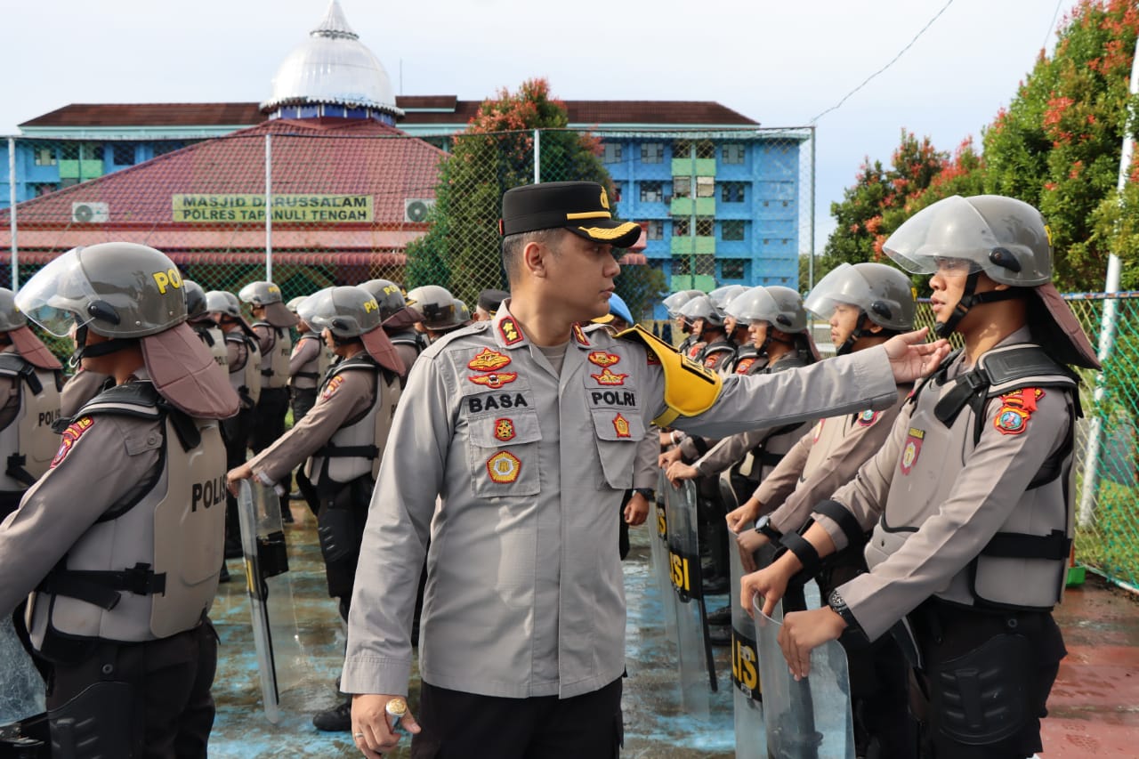 Kapolres Tapteng, AKBP Basa Emdem Banjarnahor sedang mengecek sikap tampang personel saat gelar apel kesiapan pengamanan tahapan kampanye Pemilu 2024 di Lapangan Apel Polres setempat, Senin (4/12). (ist).