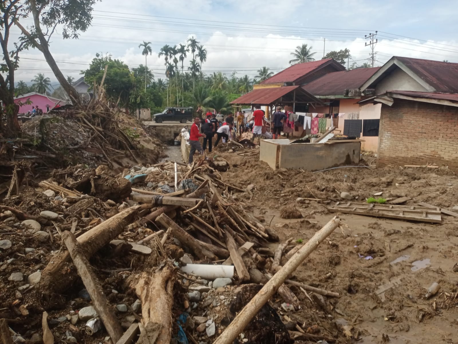 Membersihkan : Tim ASN Kecamatan Ketambe dan Puluhan Pengulu Kute dan Perangkatnya Senin (04/12) tampak melakukan aktivitas membersihkan material tanah, batu dan kayu kiriman dari perkarangan rumah warga dan jalan liingkungan Dusun Rambutan dan Ayu Ara, Kute Rikit Bur kecamatan Bukit Tusam. Berita Sore/Husaini Amin