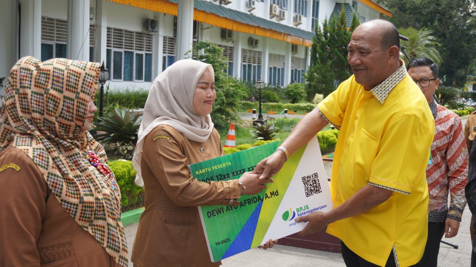 Teks Foto/Beritasore/ist  Plt. Bupati Langkat H. Syah Afandin, SH menyerahkan simbolis BPJS ketenagakerjaan untuk Operator Sekolah dan kecamatan di Kantor Bupati Langkat, Selasa (12/12/2023)