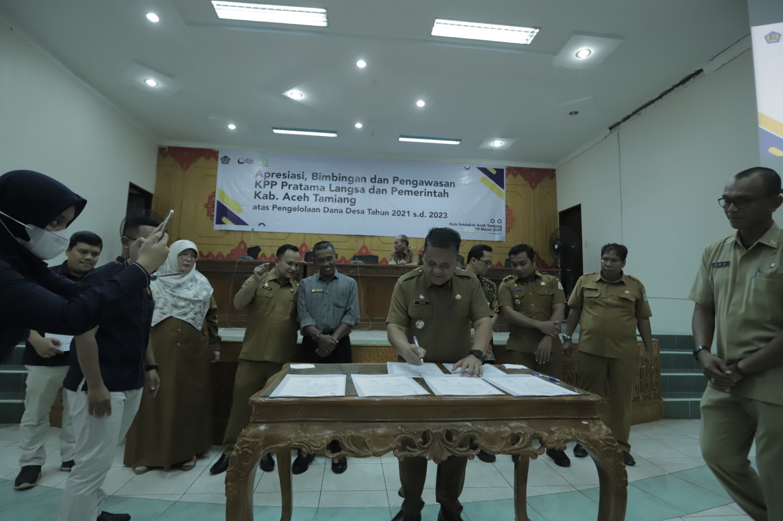 Teks foto : Simbolik penandatanganan komitmen kepatuhan pembayaran pajak yang dilakukan oleh paraDatok Penghulu Suka Jadi, Camat Rantau, Kepala DPMKPPKB, Kepala BPKD, Inspektur Kabupaten, Kepala KPP Pratama Langsa, dan Pj. Bupati Aceh Tamiang Asra.
