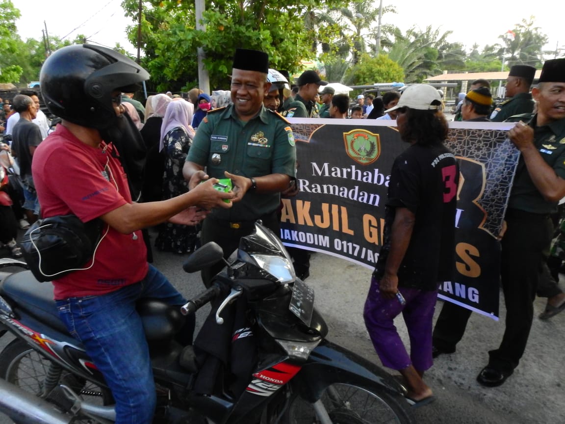 Teks foto : Keluarga besar Kodim 0117/Aceh Tamiang sedang membagikan takjil kepada pengendara sepeda motor dan perjalanan kaki di depan masjid syuhada Desa Bundar, Kecamatan Karang Baru, Kabupaten Aceh Tamiang, Jumat (22/3).