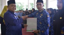 Teks foto : Pj. Bupati Aceh Tamiang, Drs. Asra, saat menyerahkan SK secara simbolis kepada perwakilan PPPK formasi tahun 2023 di tribun lapangan upacara Kantor Bupati setempat, Jumat (22/3).
