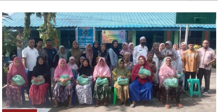 Teks.Kepala Sekolah SMPN 4 Basrah Lubis foto bersama usai mengelar acara penyerahan santunan di halaman sekolah jalan Kongsi Desa Sei Semayang