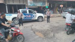 Satlantas Polres Abdya, mengatur arus lalin kendaraan di jalan rusak, kawasan perempatan Jalan Selamat pusat kota Blangpidie. Kamis (6/3).(ist). 
