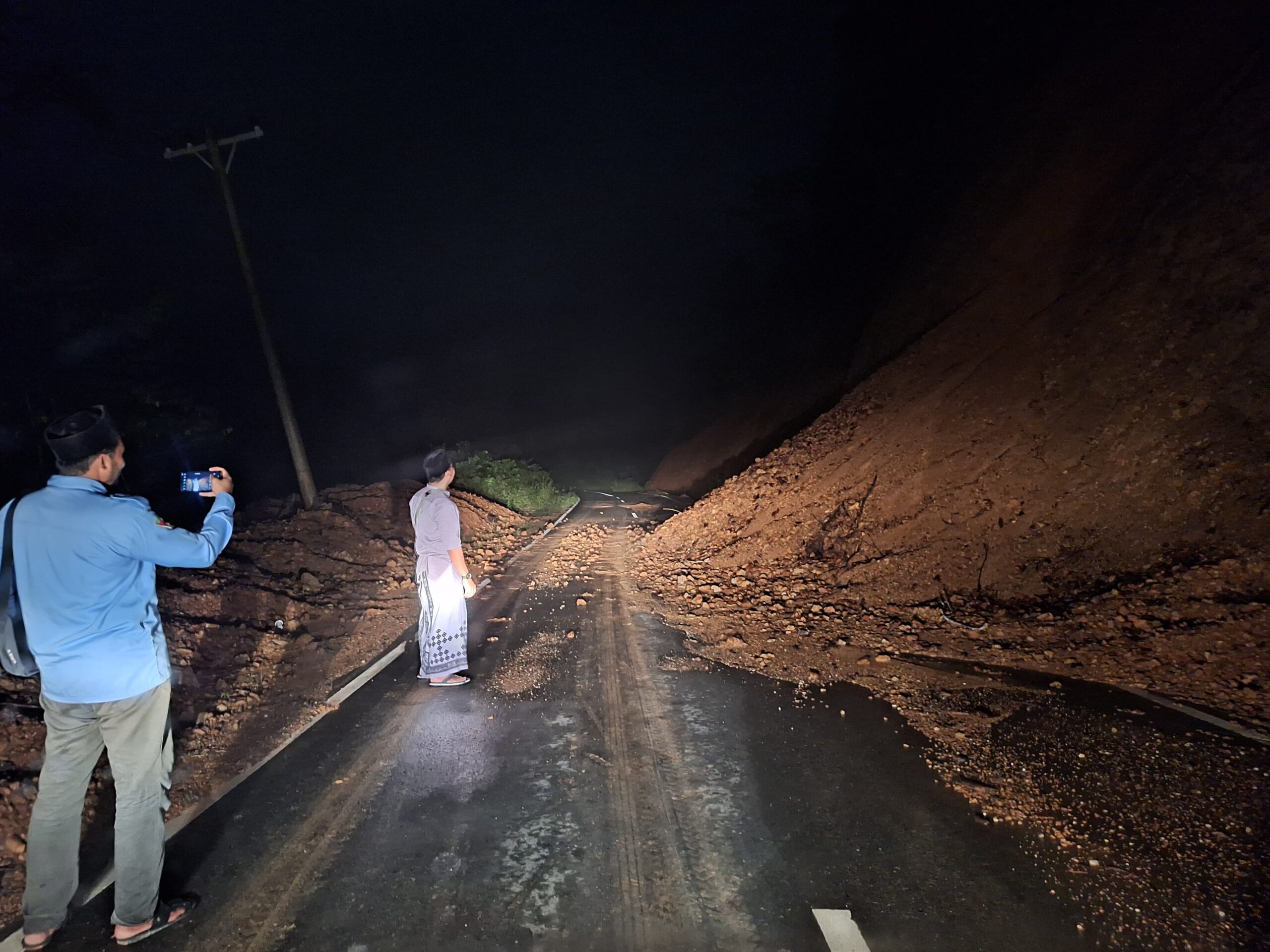 LONGSOR: Pengguna jalan melihat tanah longsor yang menutupi sebagian badan jalan lintas Peureulak - Blang Kejeren, tepatnya di Gunung Bunin, Serbajadi, Aceh Timur, Sabtu (8/3) malam.(ist). 