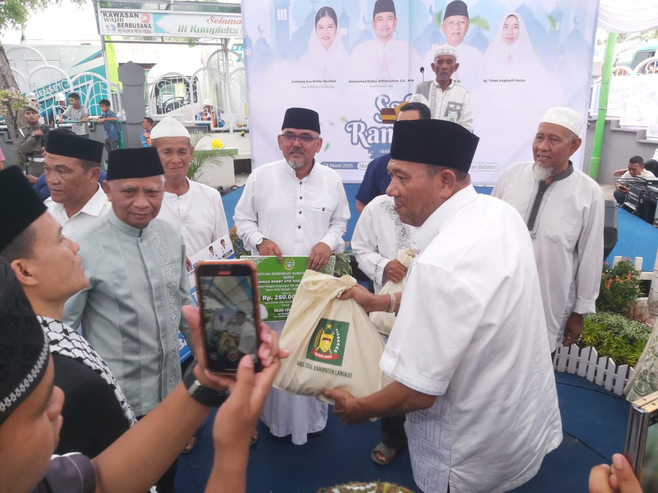 Bupati Langkat H.Syah Afandin dan Wagubsu H Surya menyerahkan bantuan di Halaman Masjid Ubudiyah P.Brandan, Jumat (14/3/25). Beritasore/Boy Aprizal 