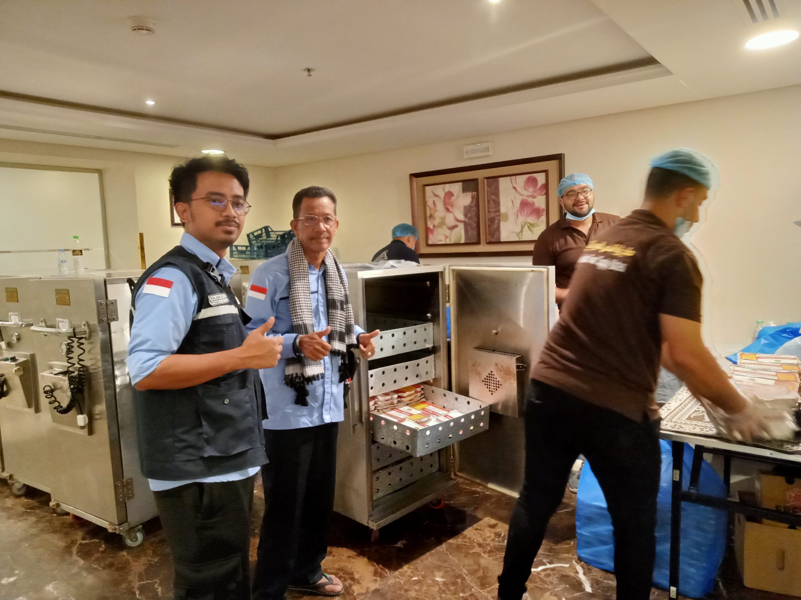 Teks foto: Ketua Kloter 08 Embarkasi Medan memantau proses distribusi konsumsi bagi jamaah haji