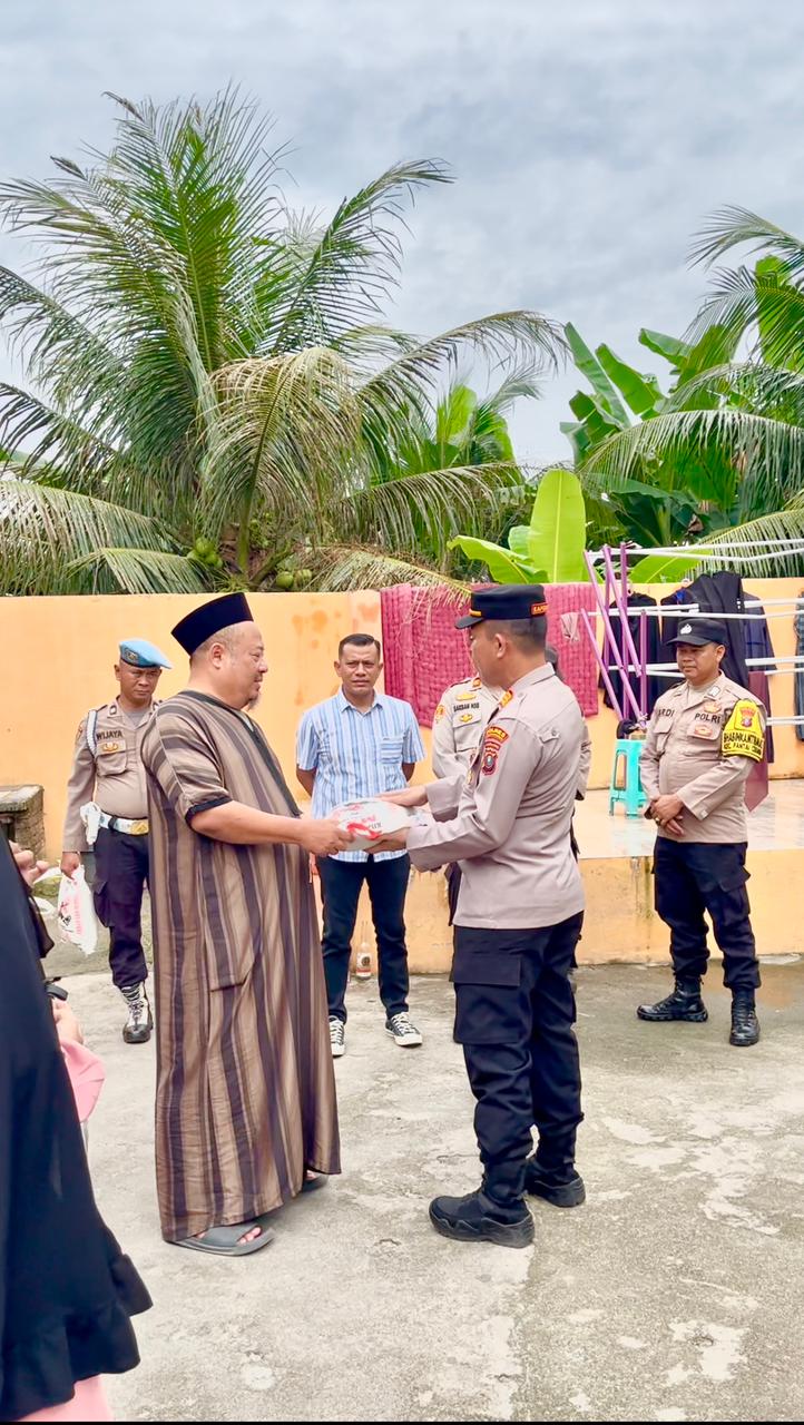 Kapolsek Pantai Cermin, AKP Herwin, SH, menyerahkan babtuan kepada Ustad Khairul Rijal, Pimpinan Ponpes Tahfiz Quran Hasbabul Hidayah, Pantai Cermin, Jumat, 16 Mei 2025.(Beritasore-Azwen)