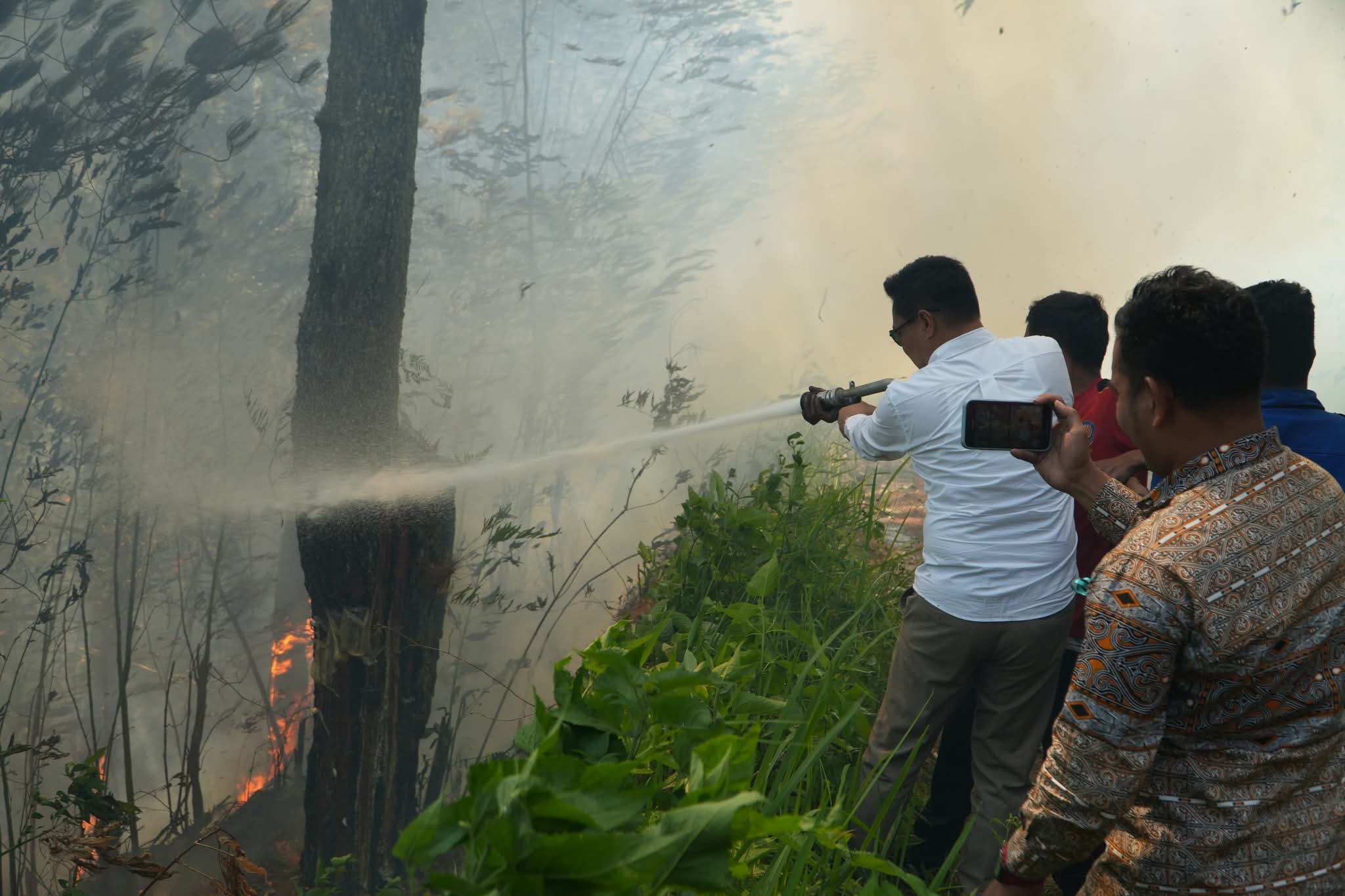 Ket Foto. BUPATI Humbahas, Oloan Paniaran Nababan terlibat langsung dalam upaya pemadaman kebakaran lahan di perbukitan Baktiraja-Lintongnihuta.(Ist). 