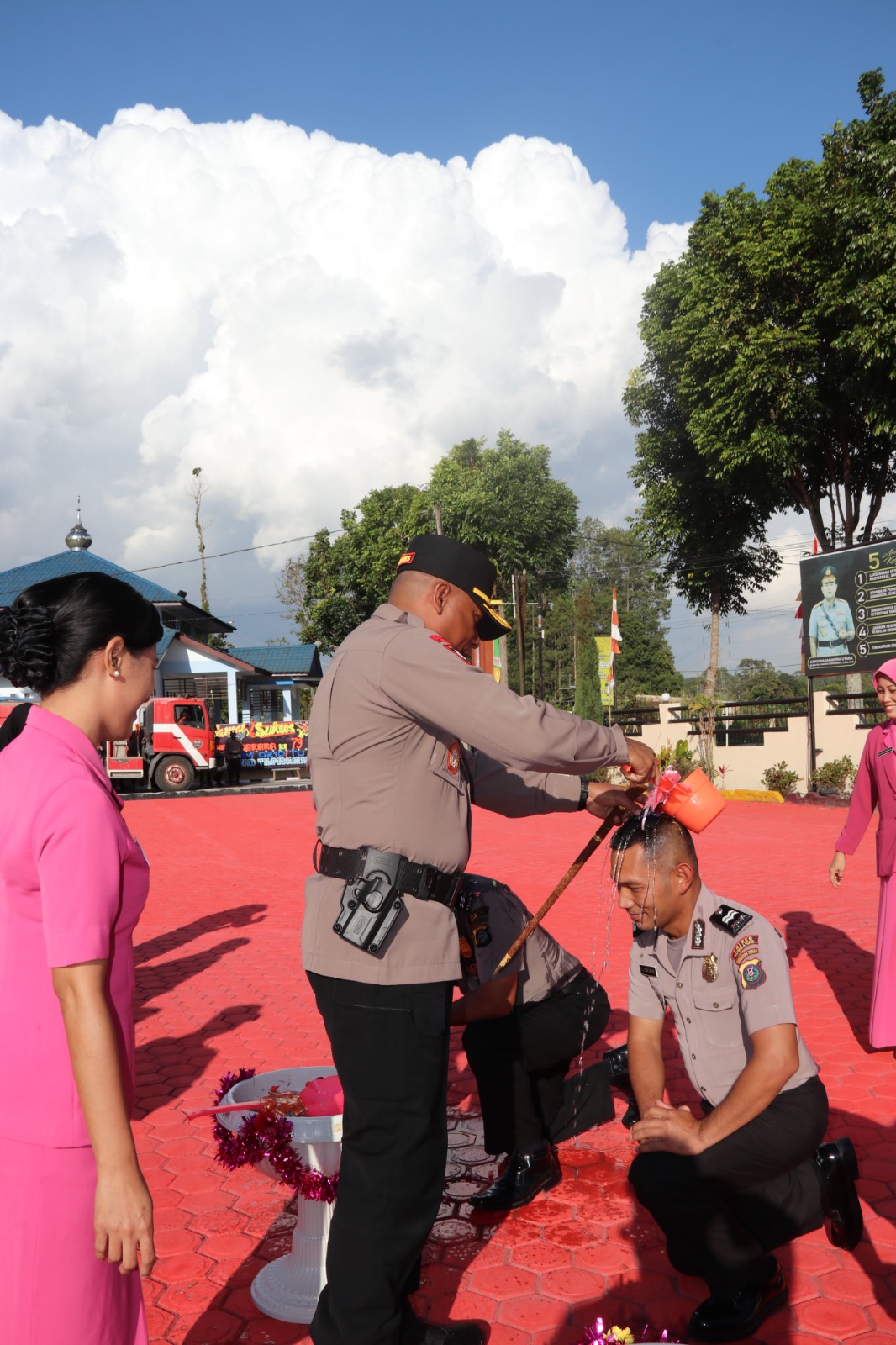 Ket Foto. KAPOLRES Humbahas, AKBP Arthur Sameaputty memandikan air bunga kepada personel yang naik pangkat. (Ist). 
