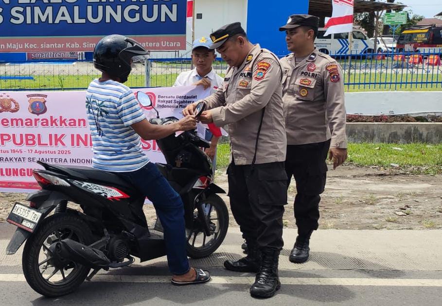 Ket.gbr: Personel Polres Simalungun dibantu para pelajar membagikan bendera merah putih dalam rangka sambut perayaan HUT ke 80 RI, Selasa (5/8).(ist).