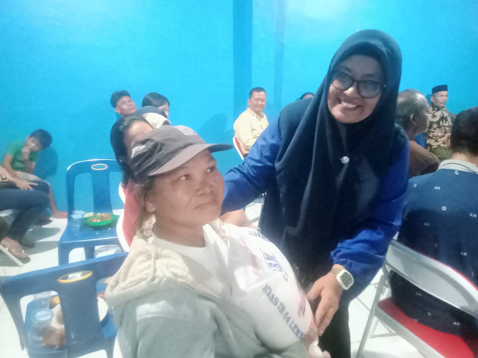 Teks.Kepala Desa Pujimulyo Hj.Armadaiyah Sinaga saat menyerah kan beras kepada warga