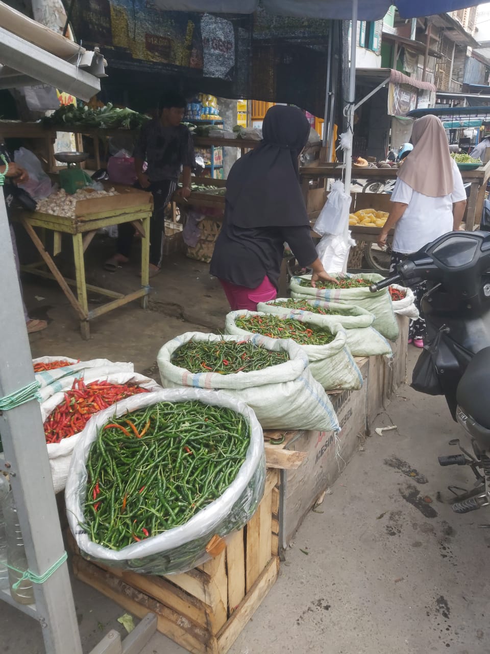 Teks Foto  Pedagang sayur mayur di Pasar Tradisional P.Brandan saat melayani pembeli, Sabtu(1/11/25).Beritasore/Boy Aprizal