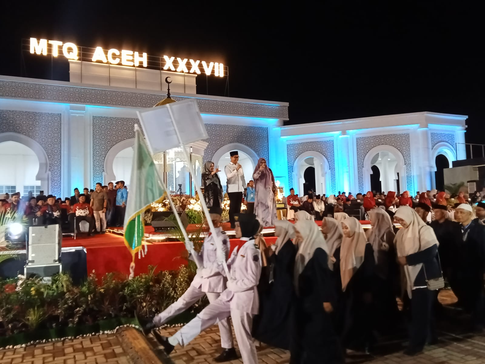 Teks Foto : Wakil Wali Kota Langsa Muhammad Haikal Alfisyahrin, ST, didampingi Plt Kadis Syariat Islam Rika Mariska, SSTP, MH, dan Kabid Bina Syariat Islam Mastura Idris, SH, diatas Panggung Utama saat Devile Kafilah Kota Langsa, pada malam pembukaan MTQ XXXVII Aceh Tahun 2025 di Pidie Jaya, Sabtu (1/11).(ist) 