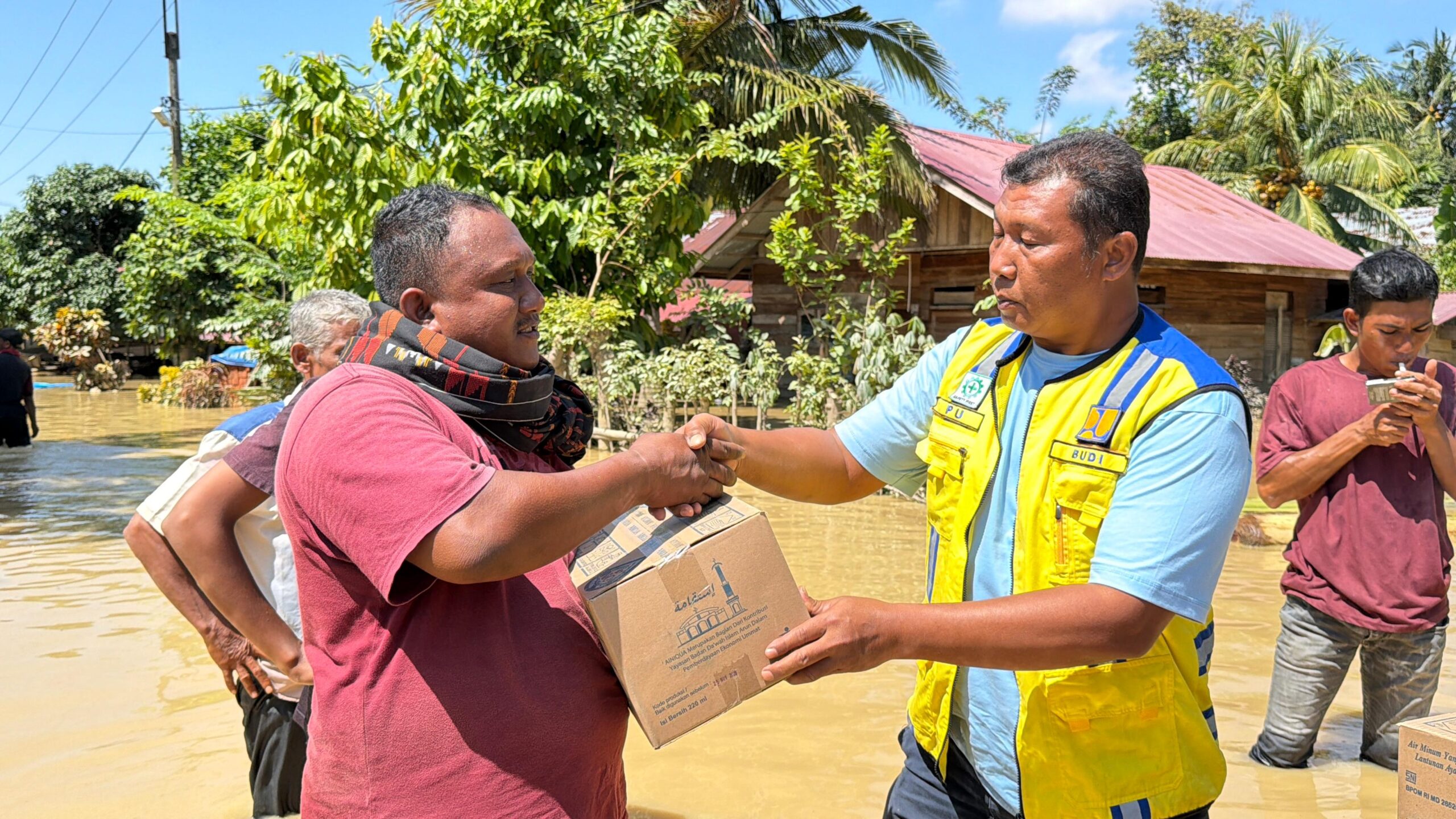 Teks Foto: Ketua Unit Pengelolaan Irigasi (UPI) Jambo Aye-Langkahan Setia Budi sedang menyerahkan bantuan kepada warga korban banjir Aceh Utara, Senin (1/12). Ist