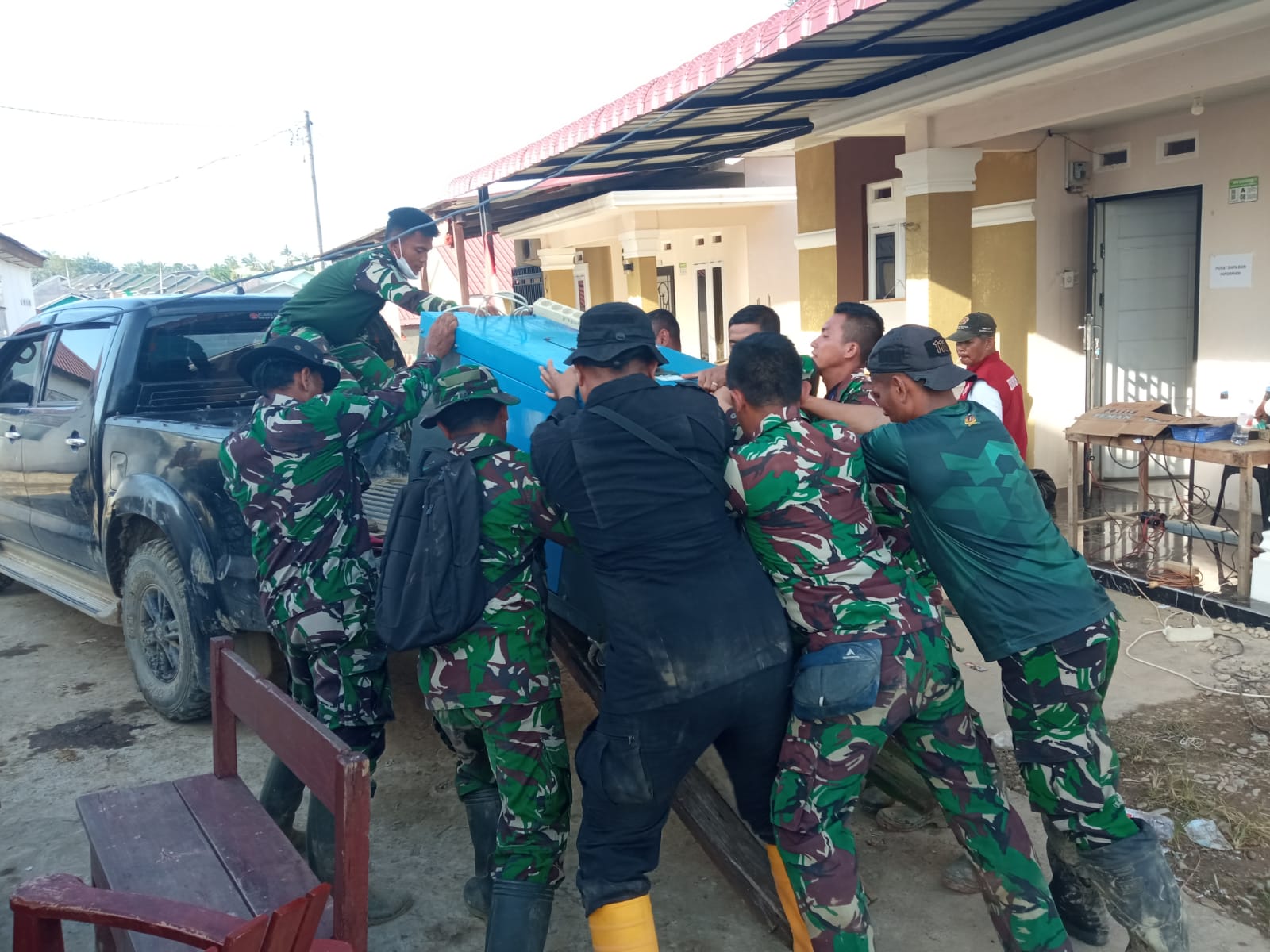 Sejumlah anggota TNI sedang mengangkat genset untuk dibawa ke Posko yang baru di lapangan Tribun Kantor Bupati Aceh Tamiang, Minggu(7/12) sore. Foto: