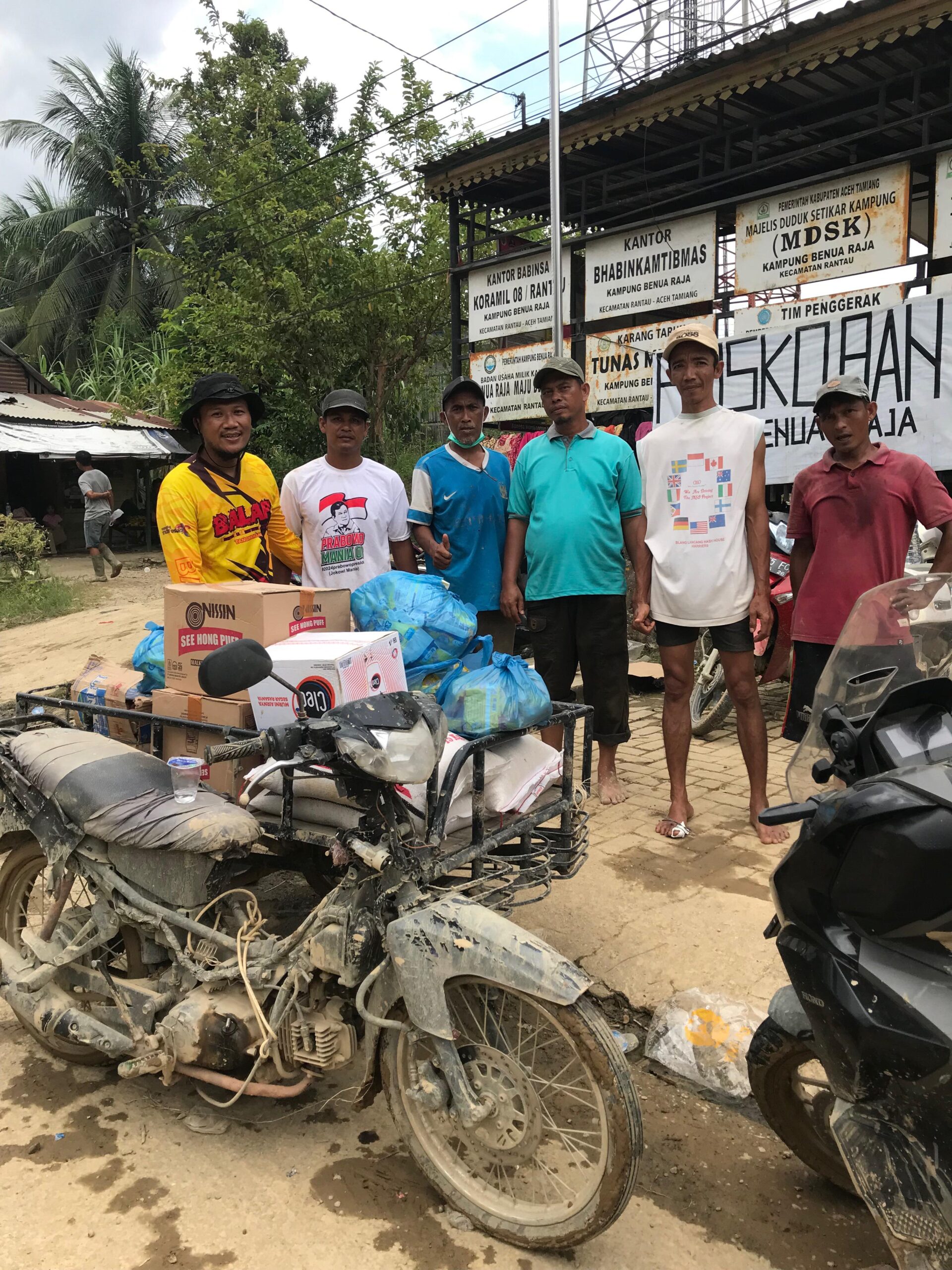 Juanda (baju kuning) salah seorang tokoh masyarakat Aceh Tamiang saat menyalurkan bantuan untuk korban banjir.(Foto: Yusri).