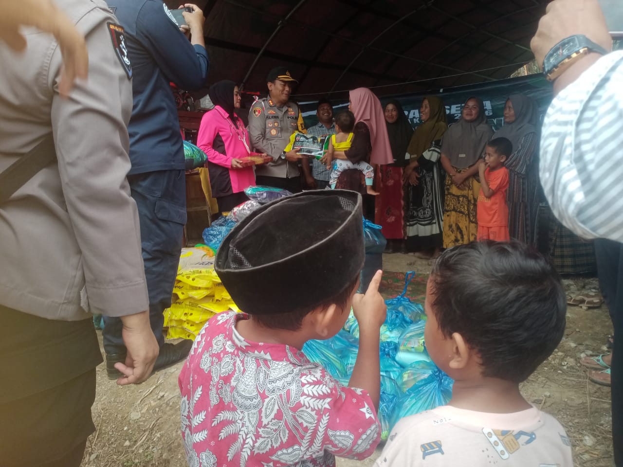 Menunjuk : Tampak salah satu anak warga Kute Bener Bepapah Kecamatan Ketambe tengah menunjuk, saat Kapolres Agara AKBP Yulhendri S.IK tengah menyerahkan bantuan secara simbolis.Tampak didampingi Ketua Agara Bhanyangkari.Ny Ilma Yulhendri dan Pengulu Kute Bener Bepapah.Gambar di abadikan Jum'at (19/12). Berita Sore/Husaini Amin