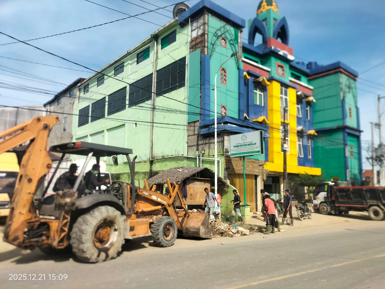 Teks Foto: Alat berat PT Timbang Langsa bantu proses pembersihan pasca banjir di di Jalan Prof A Majid Ibrahim (Jalan Medan-Banda Aceh) Kota Langsa, Minggu (21/12). Foto: Munawar