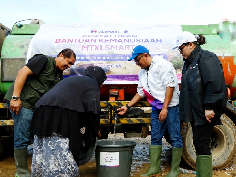Keterangan Foto : FOTO 1 : (Ki-Ka) Head of Sales XLSMART Northern 1, Horas Lubis (paling kiri), warga Desa Lubuk Sidup, Chief Enterprise Business Solution XLSMART sekaligus Ketua Umum Majelis Ta’lim XLSMART, Feby Sallyanto (kedua dari kanan), dan Group Head XLSMART West Region, Desy Sari Dewi (paling kanan) saat penyaluran air bersih di Desa Lubuk Sidup, Kecamatan Sekerak, Kabupaten Aceh Tamiang, pada Sabtu (20/12). XLSMART melalui Majelis Ta’lim XLSMART (MTXLSMART) menyalurkan bantuan kemanusiaan bagi masyarakat yang terdampak bencana banjir dan longsor di sejumlah wilayah Sumatra, meliputi Sumatera Utara, Aceh, dan Sumatera Barat.(berita sore/Zul)