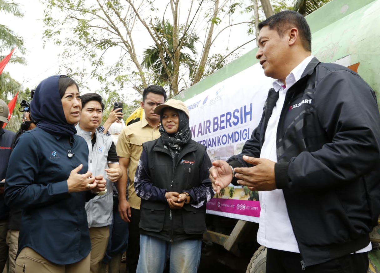 Head of Sales XLSMART Northern 1 West, Horas Lubis (kanan) bersama Menteri Komunikasi dan Digital Republik Indonesia, Meutya Viada Hafid saat mengunjungi lokasi penyaluran bantuan air bersih dari XLSMART di Kantor SAMSAT Aceh Tamiang pada Minggu (28/12). Berita/ Ist.