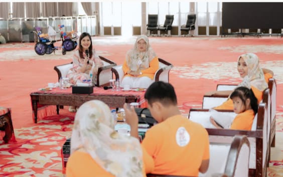 Teks foto: Ketua Tim Penggerak Pemberdayaan dan Kesejahteraan Keluarga (TP PKK) Provinsi Sumatera Utara (Sumut) Kahiyang Ayu, menyerahkan secara simbolis 135 kursi roda adaptif bagi anak penyandang Cerebral Palsy (CP) di 12 kabupaten/kota se-Sumut. Penyerahan bantuan dilakukan bersama Direktur Global Village Foundation, Mr Andy Baracey, di Aula Tengku Rizal Nurdin, Jalan Sudirman, Medan, Rabu (18/2/2026).