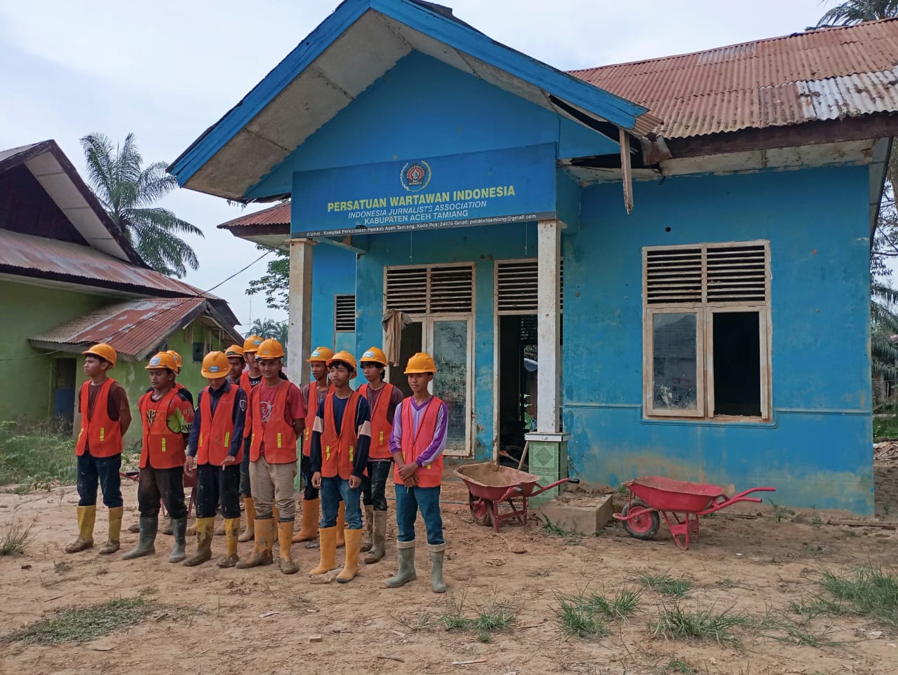 Teks foto : Tampak sejumlah personil PT WIKA Divisi Aceh Tamiang mengenakan Alat Pelindung Diri (APD) dan menggunakan peralatan Cangkul, Sekop dan gerobak dorong saat akan melakukan pembersihan endapan lumpur di Kantor PWI Aceh Tamiang.