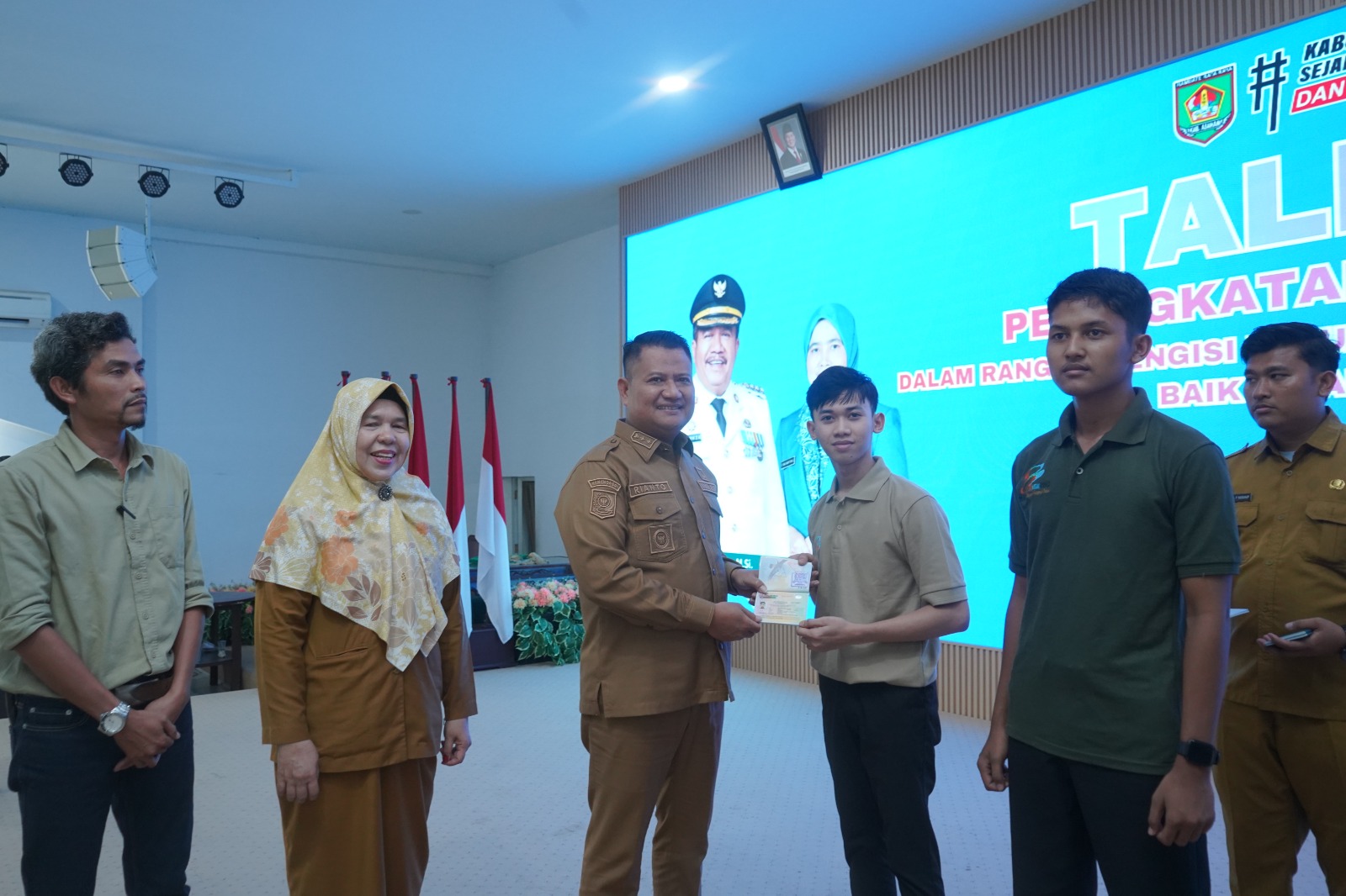 Teks fhoto Wakil Bupati Asahan Rianto SH,M.AP menyerahkan Paspor kepada 4 orang pencari kerja dari Kabupaten asahan ke Negara Jepang di Aula Melati Kantor Bupati Asahan Selasa (07/04/2026).beritasore/alirsyah